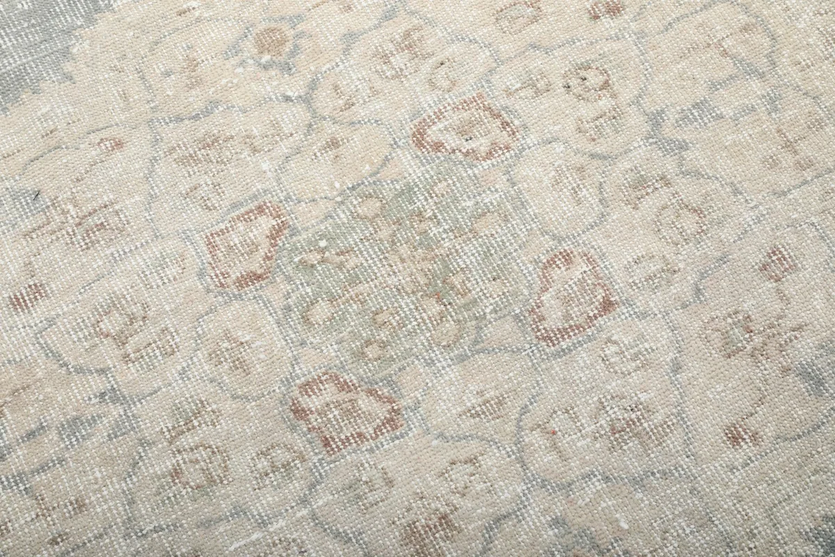 Close-up of the rug's low wool pile, showing the hand-knotted texture and vintage wear with hints of color.