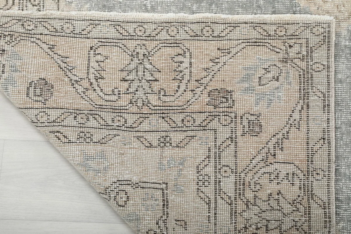 Underside of the rug's corner revealing the hand-knotted cotton foundation and detailed knotting.