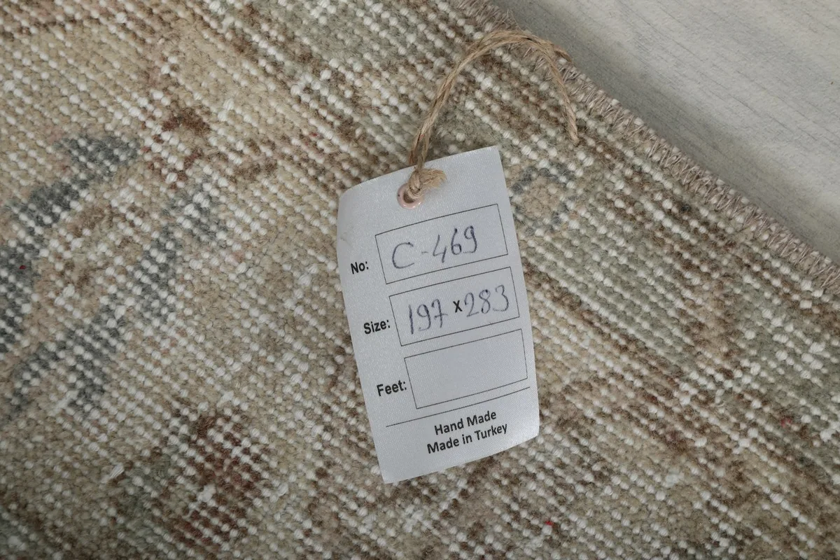 Close-up of the rug's back with a tag showing size in centimeters and origin 'Hand Made in Turkey'.
