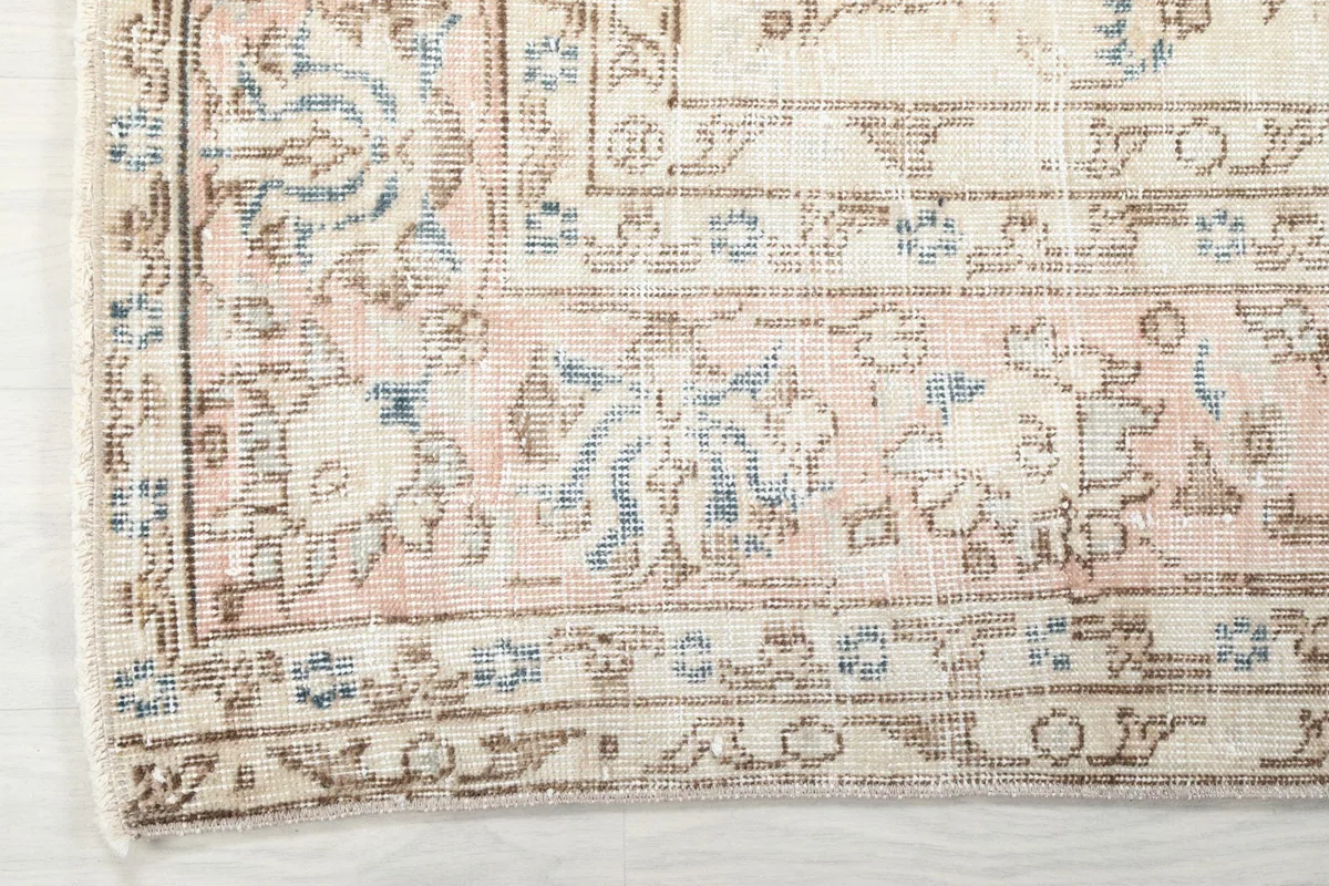 Detailed view of the rug's outer border with geometric and floral patterns