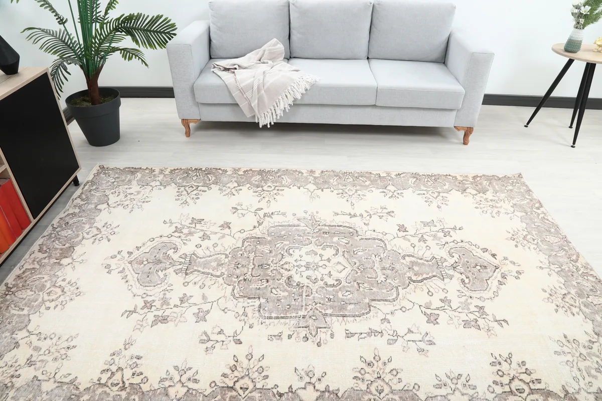 Ivory Gray Medallion Anatolian Rug, top-down view in a room with a sofa, highlighting its size and design.