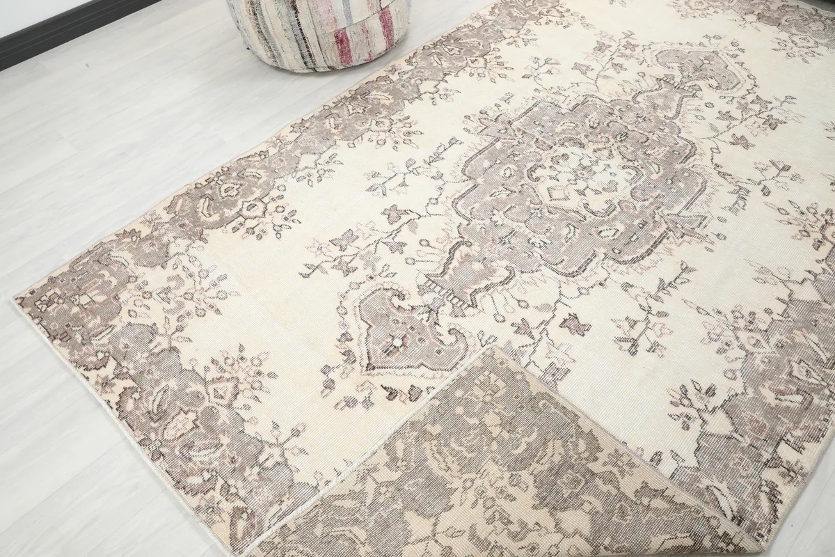 Ivory Gray Medallion Anatolian Rug, showing a folded corner to reveal the rug's thickness and reverse side.