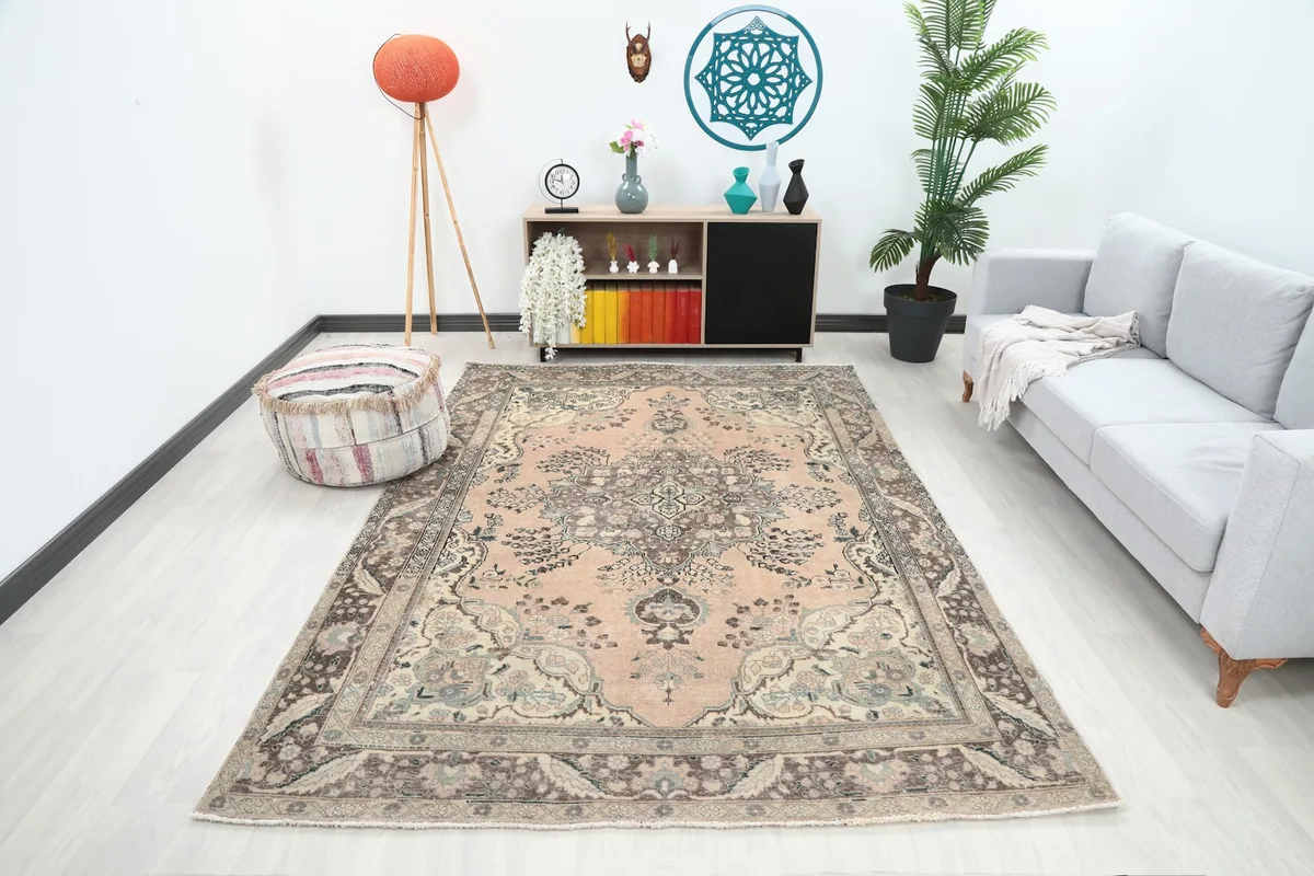 Vintage rose and brown rug in a modern living room setting with a light gray sofa