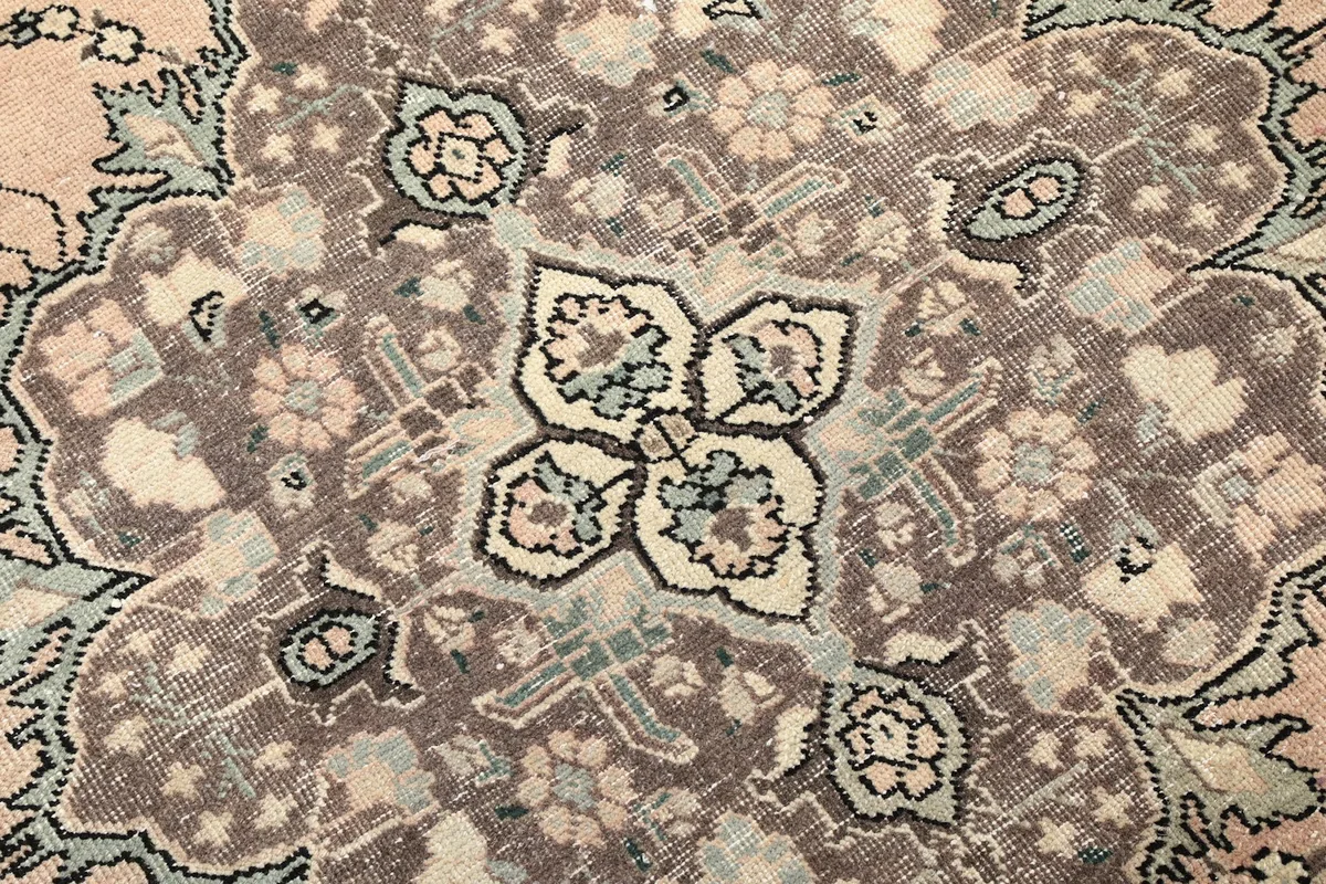 Close-up of the medallion's intricate floral and geometric patterns in the rug
