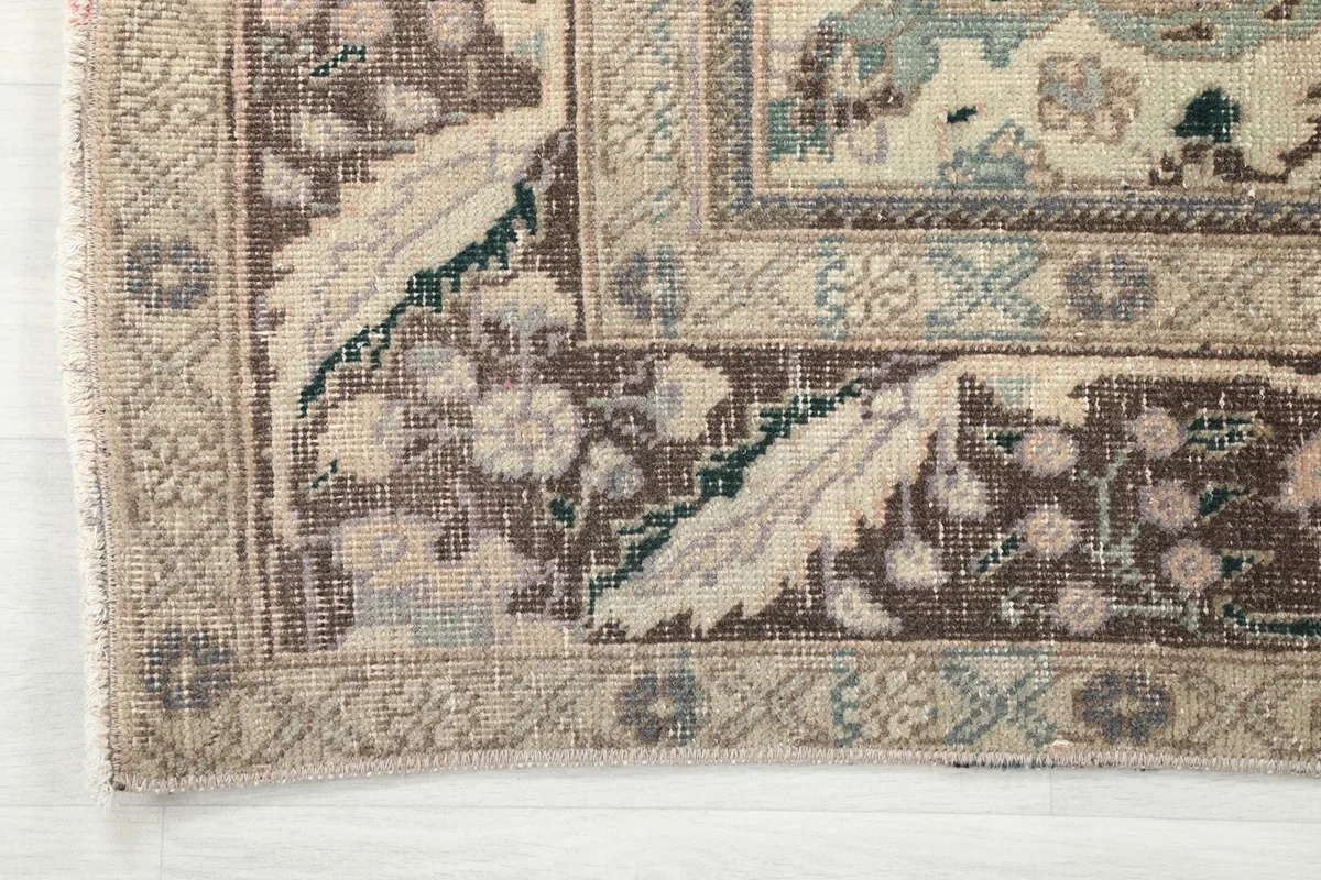 Detail of the outer brown border and inner beige border with floral motifs