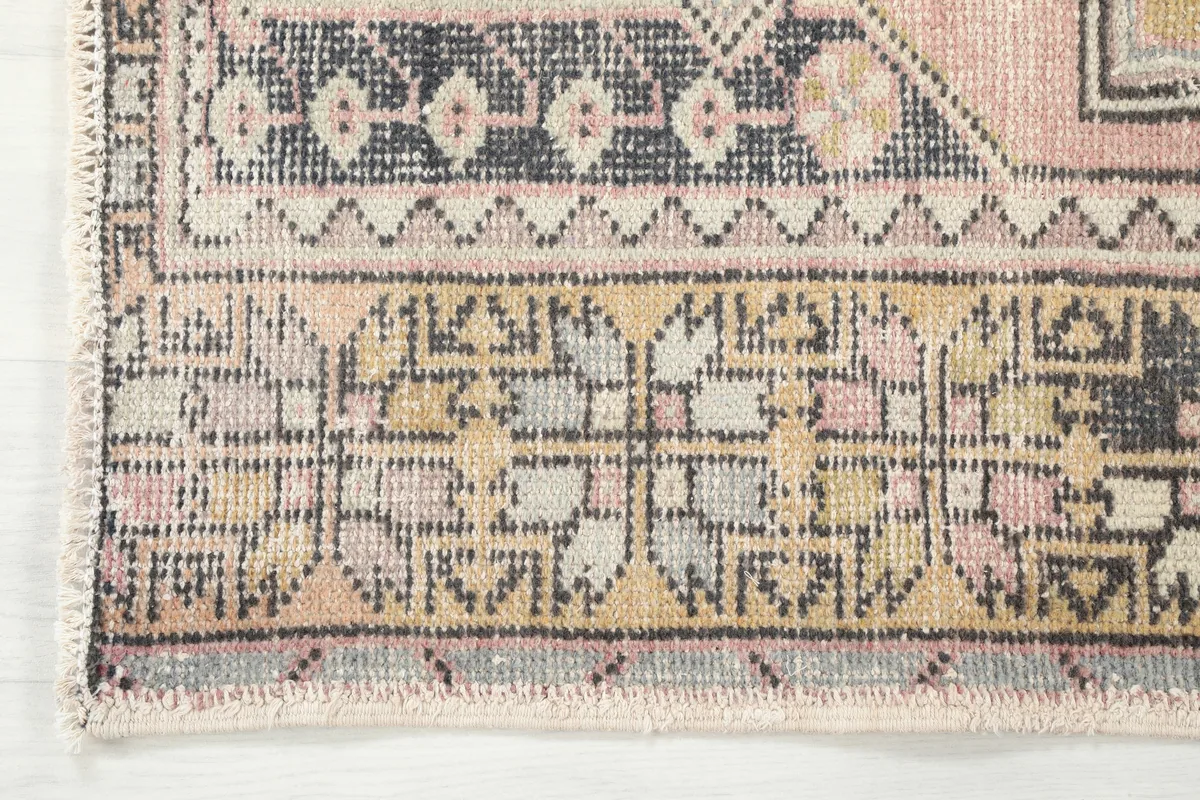 Detail of the border design of the Pink Gold Geometric Anatolian Rug, showcasing the geometric elements and color variations.