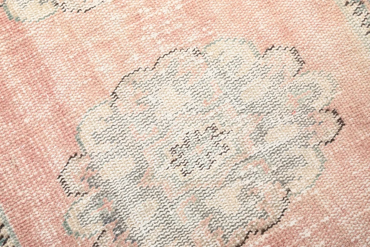 Close-up of a single gray geometric medallion with intricate patterns on the rose field