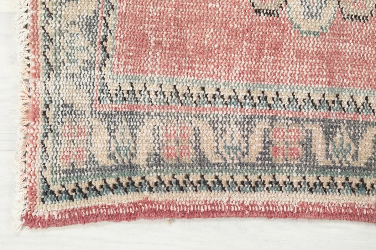 Close-up of the runner's edge, showing the detailed charcoal, beige, and blue border patterns