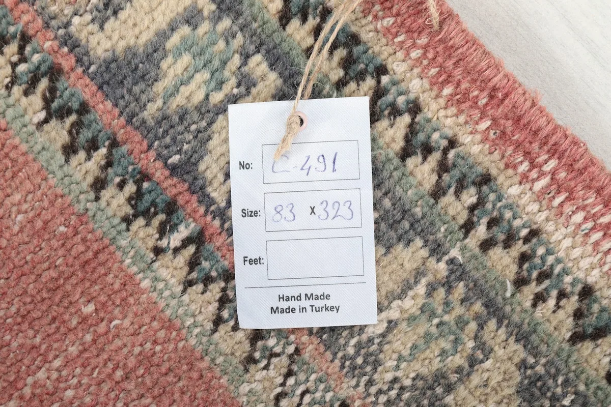 Close-up of the tag showing the rug's dimensions and origin, 'Hand Made in Turkey'