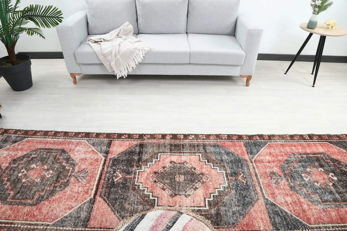 Overhead view of the runner rug extending from a grey sofa, highlighting its geometric motifs and colors.