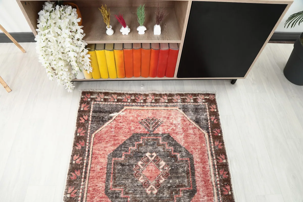 Partial overhead view of the runner rug in a room, focusing on the end section near a cabinet.