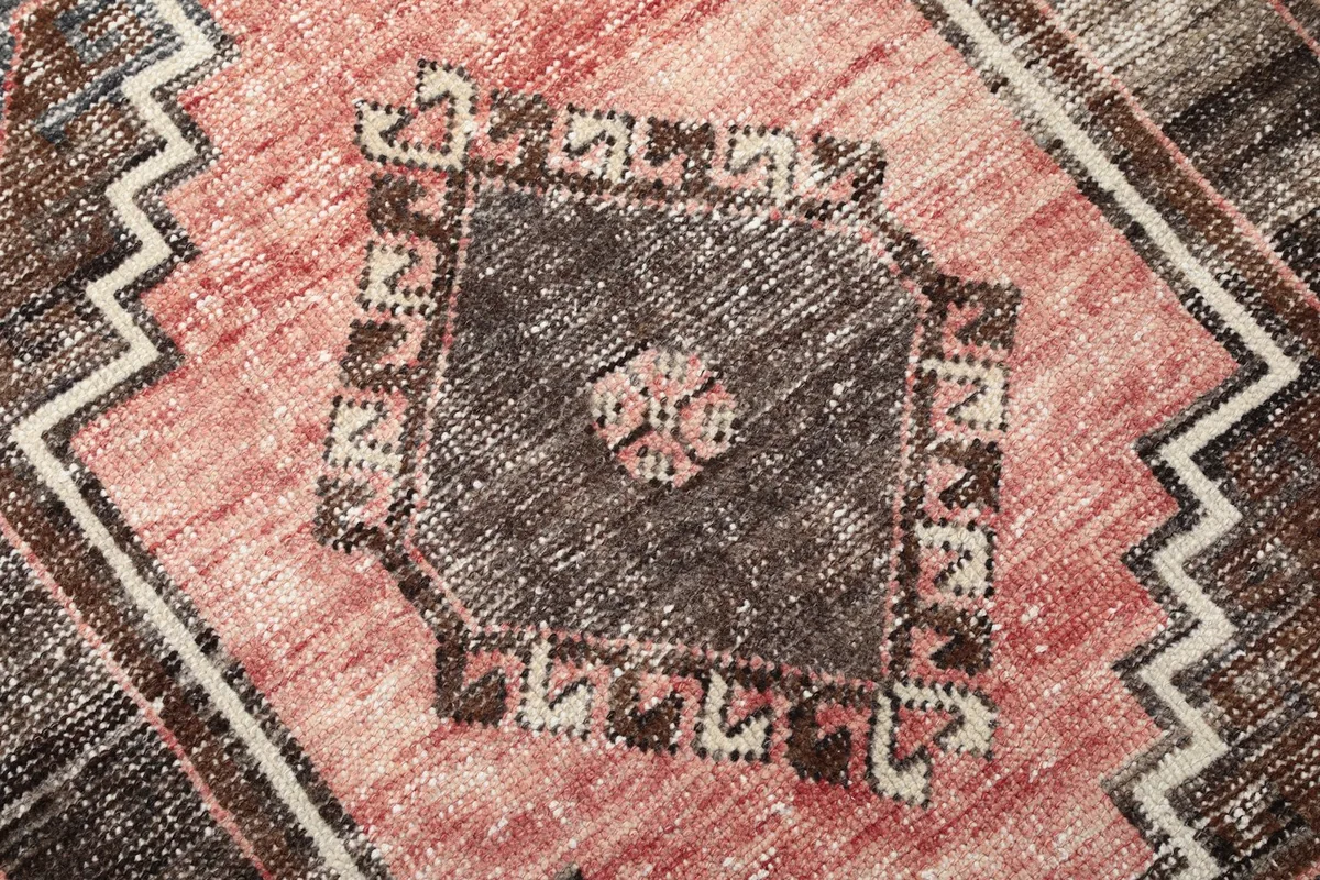 Close-up of the hand-knotted wool pile and intricate geometric design within a medallion.
