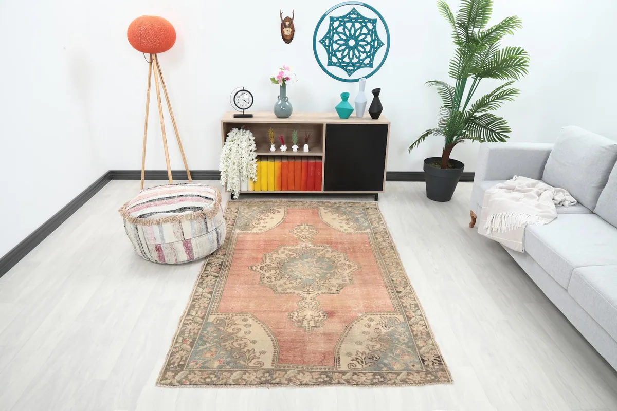 Vintage area rug in a modern living room setting with a gray sofa and wooden cabinet
