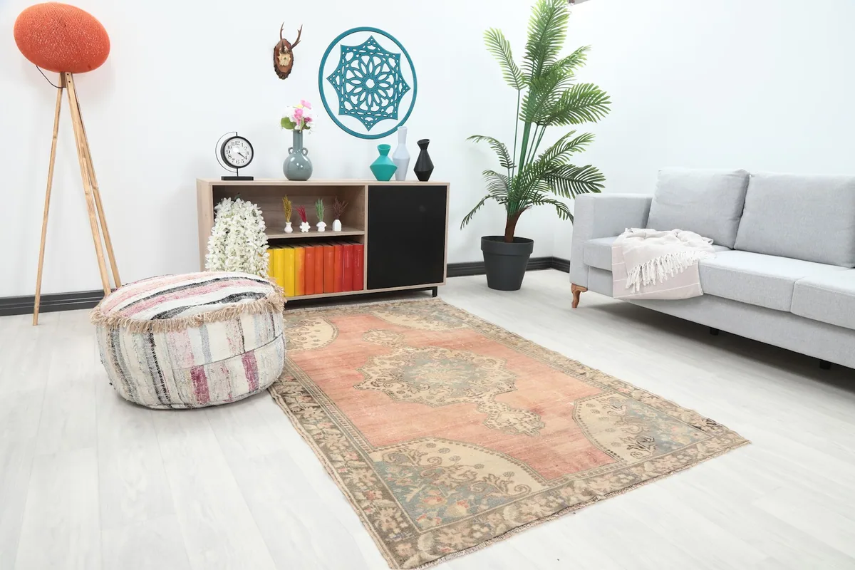 Angle view of the rose and blue vintage rug in a living space, showing its scale