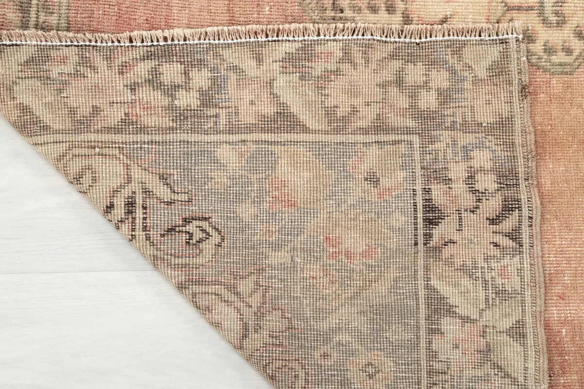 View of the rug's reverse side, showing the hand-knotted construction and fringe