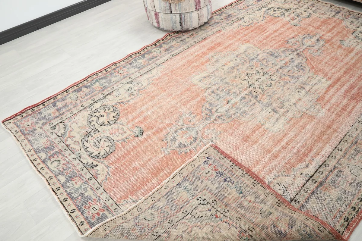 Angled view of the rug with one corner folded back slightly, revealing the underside and the overall design.