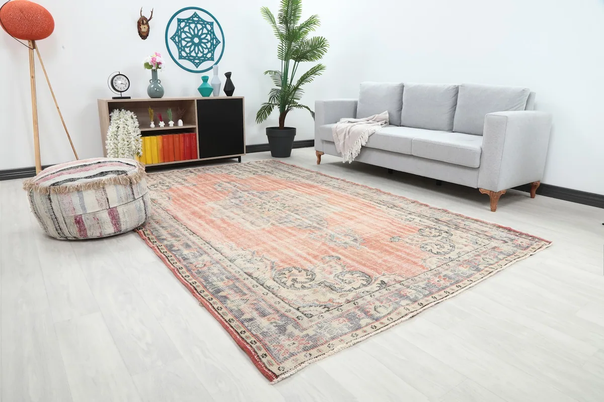 Angled view of the rust and blue vintage rug in a modern living space, showing its size relative to furniture.