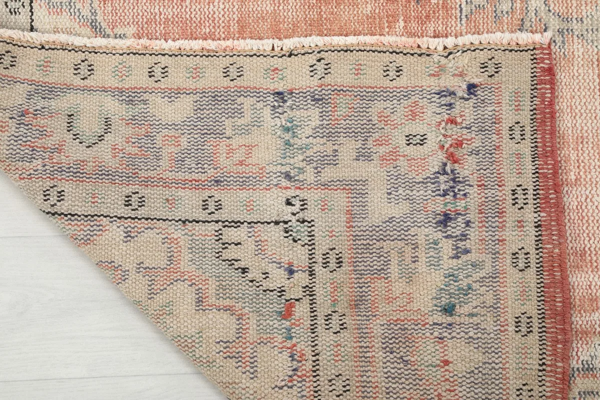 Close-up of the underside of the rug, showing the hand-knotted cotton foundation and the reverse of the patterns.