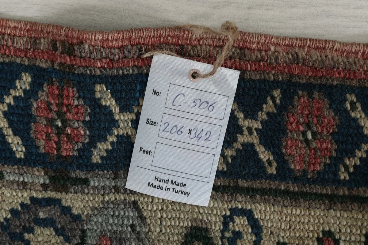 Close-up of the rug's reverse side, showing the hand-knotted foundation and tag