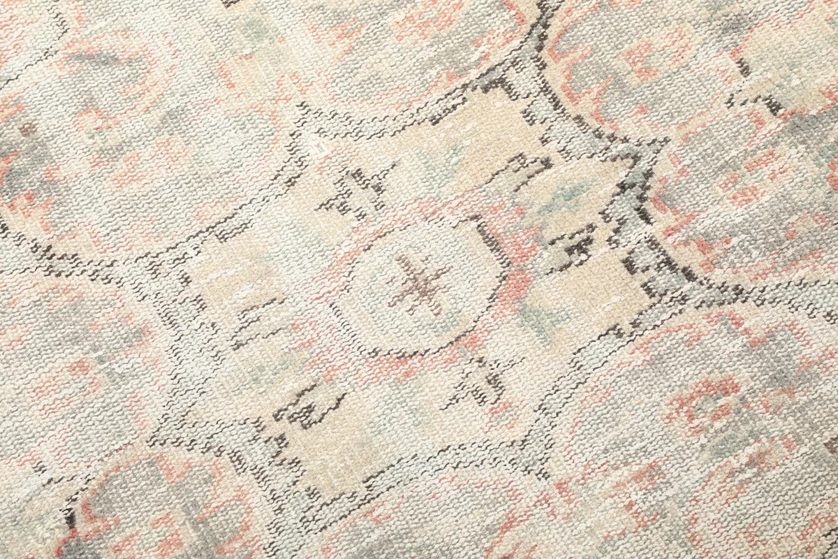Close-up detail of the intricate geometric patterns within the rug's border design