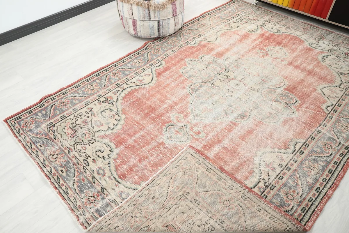View of the vintage rug with a corner folded back, showing the cotton foundation