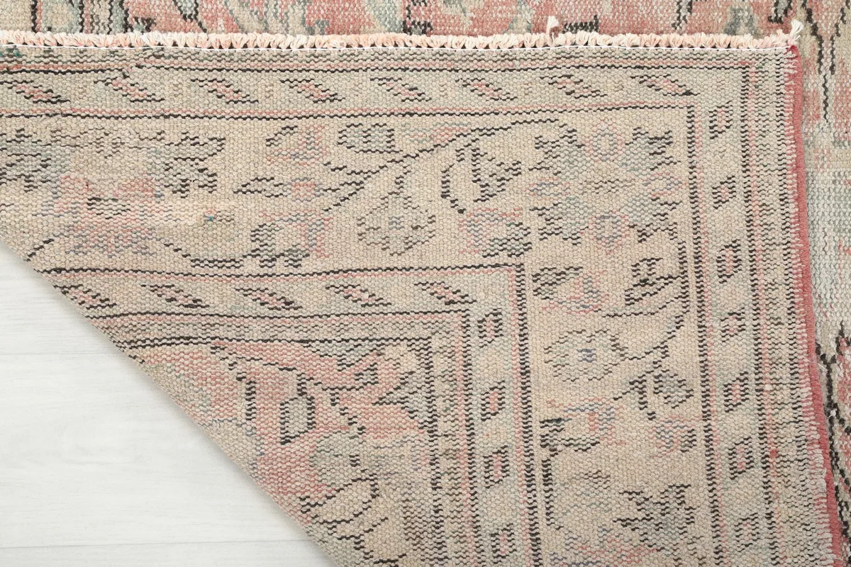 Close-up of the rug's reverse side, showing the tight knotting on the cotton foundation and the overall construction.