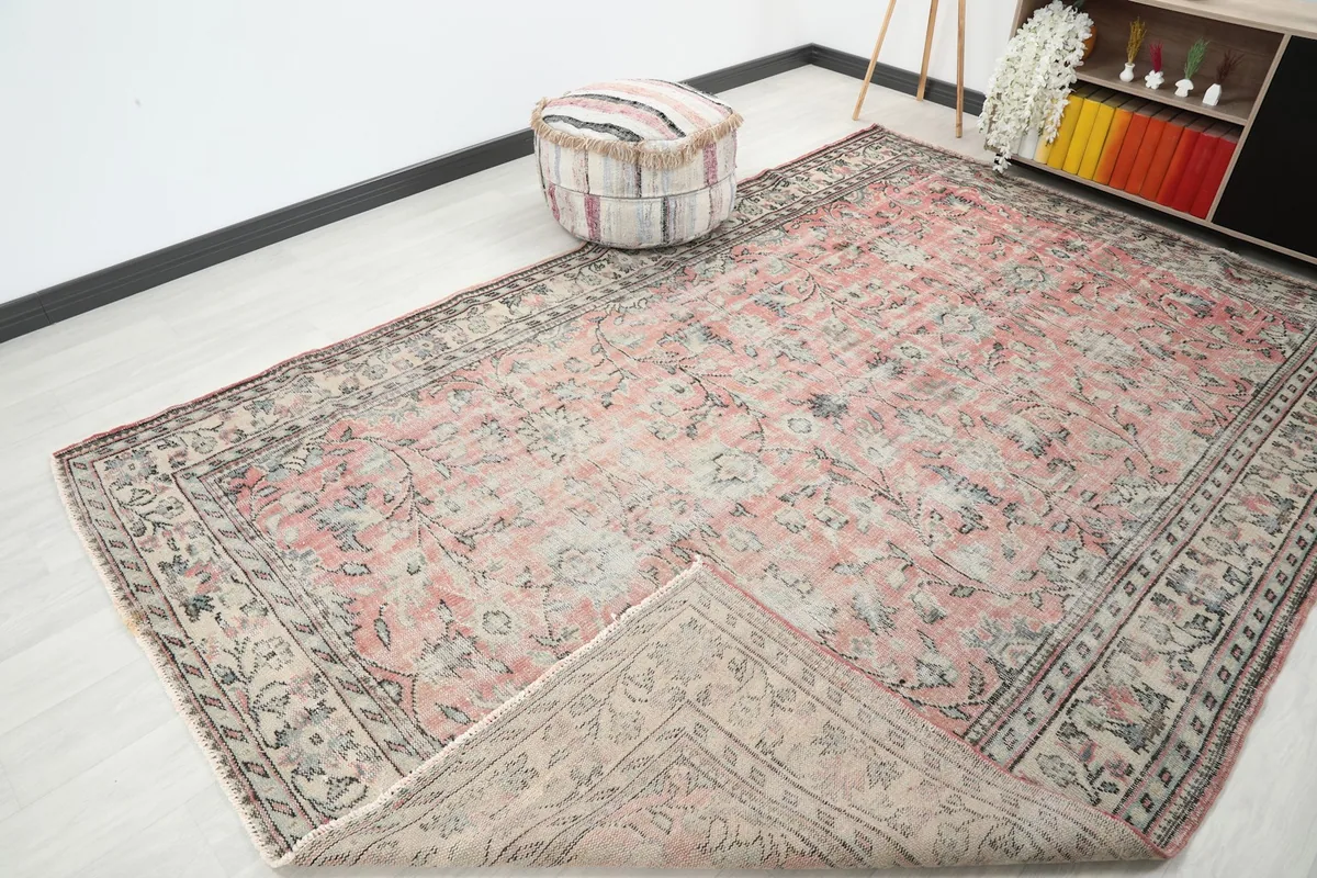 View of the rug with a corner folded back, revealing the reverse side of the hand-knotted cotton foundation.