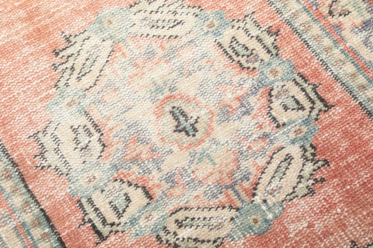 Close-up detail of a central geometric medallion with blue, rust, and ivory tones