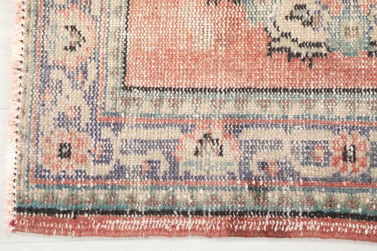 Detailed view of the intricate border pattern and colors along the edge of the rug