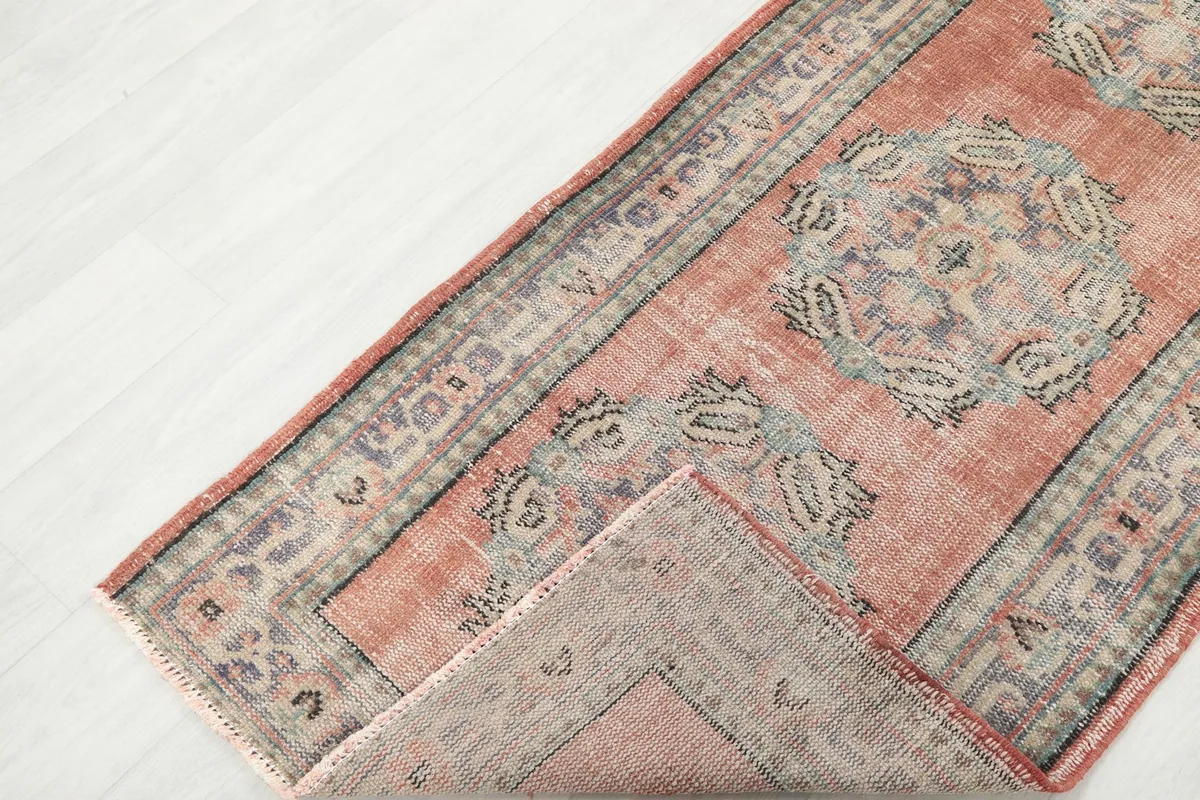 View of the runner rug folded back to show the pile and foundation texture