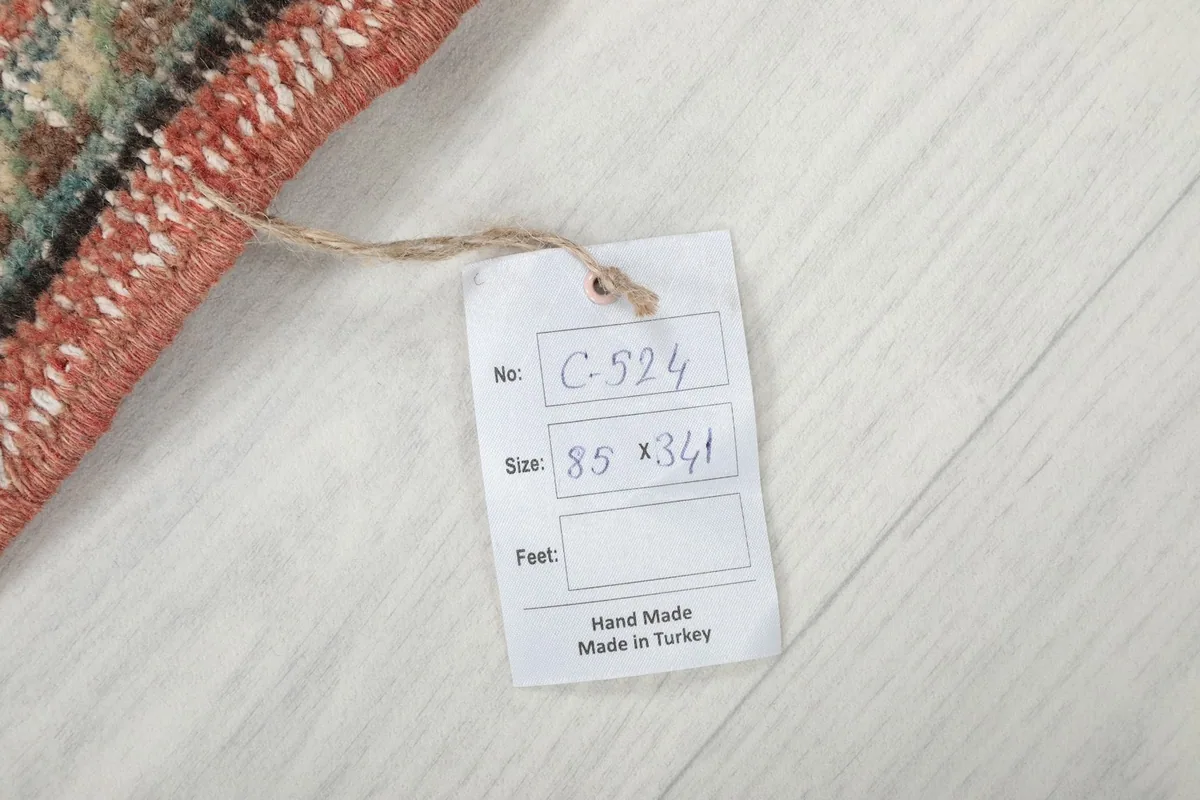 Tag on the rug showing its dimensions in centimeters and origin as hand made in Turkey
