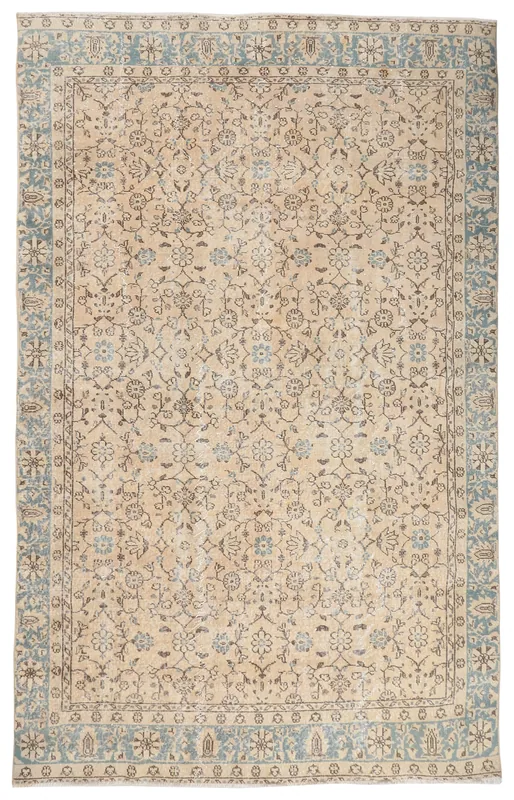 Full top view of the beige and blue floral vintage Anatolian rug on a white background.