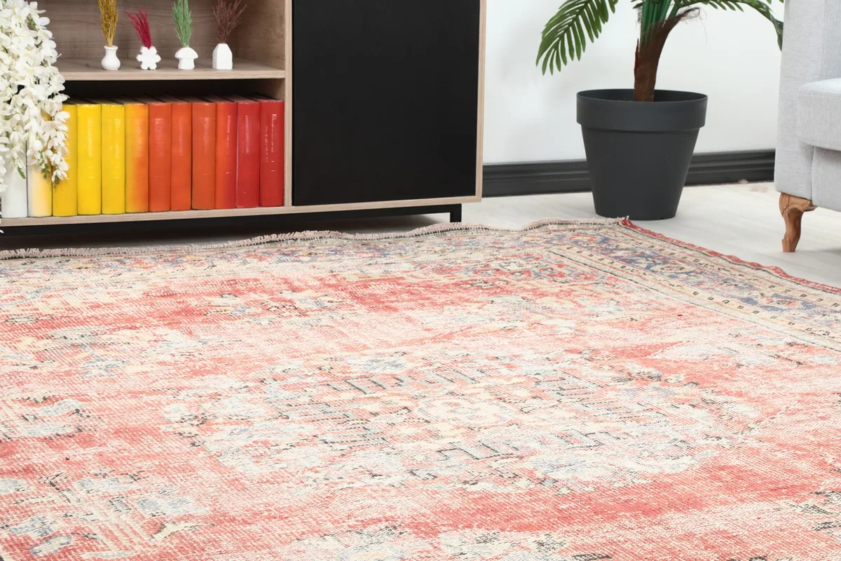 Close-up of the rug's surface and colors next to a wooden cabinet in a room setting