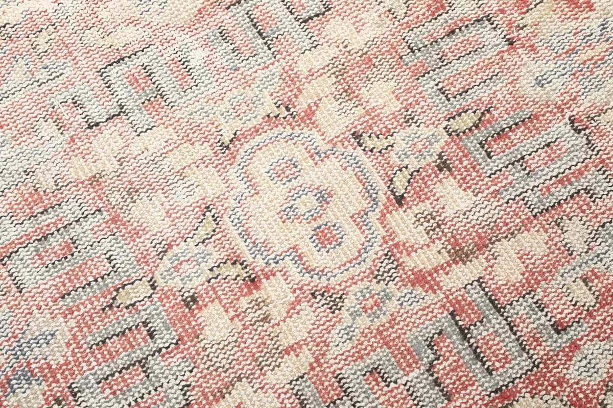 Texture and low pile of the hand-knotted wool rug, showing color variations