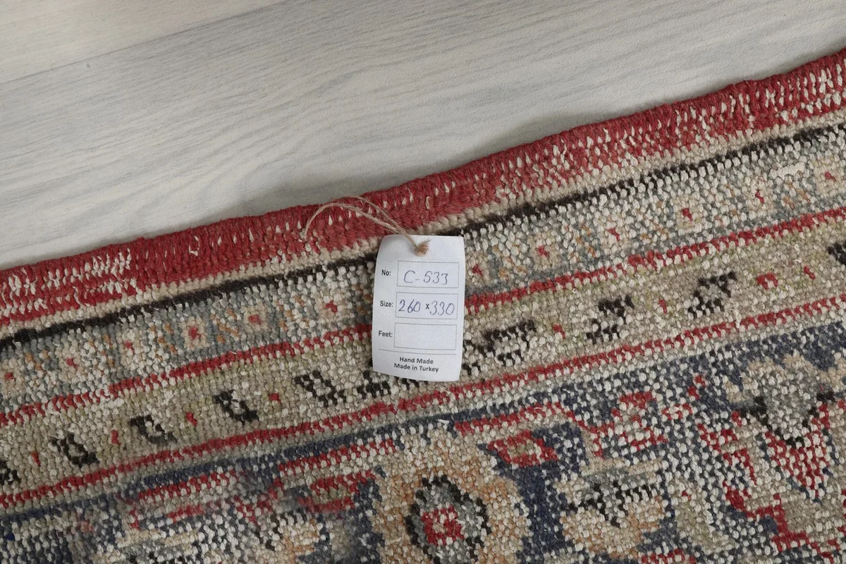 Tag showing the rug's dimensions and origin, attached to the edge of the rug