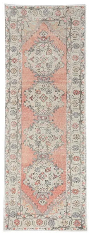 Full overhead view of the orange and beige geometric Anatolian runner rug on a white background.