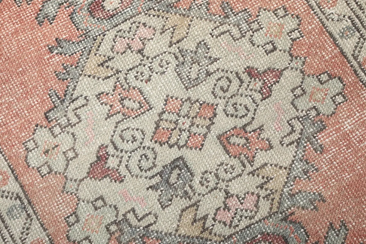 Close-up of the intricate hand-knotted patterns and wool pile texture within a central motif.