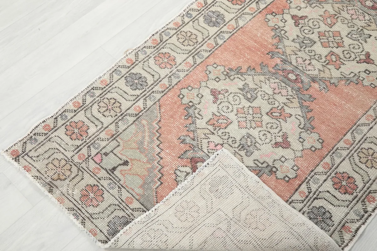 Corner of the runner rug folded back to reveal the cotton foundation and reverse side of the knots.