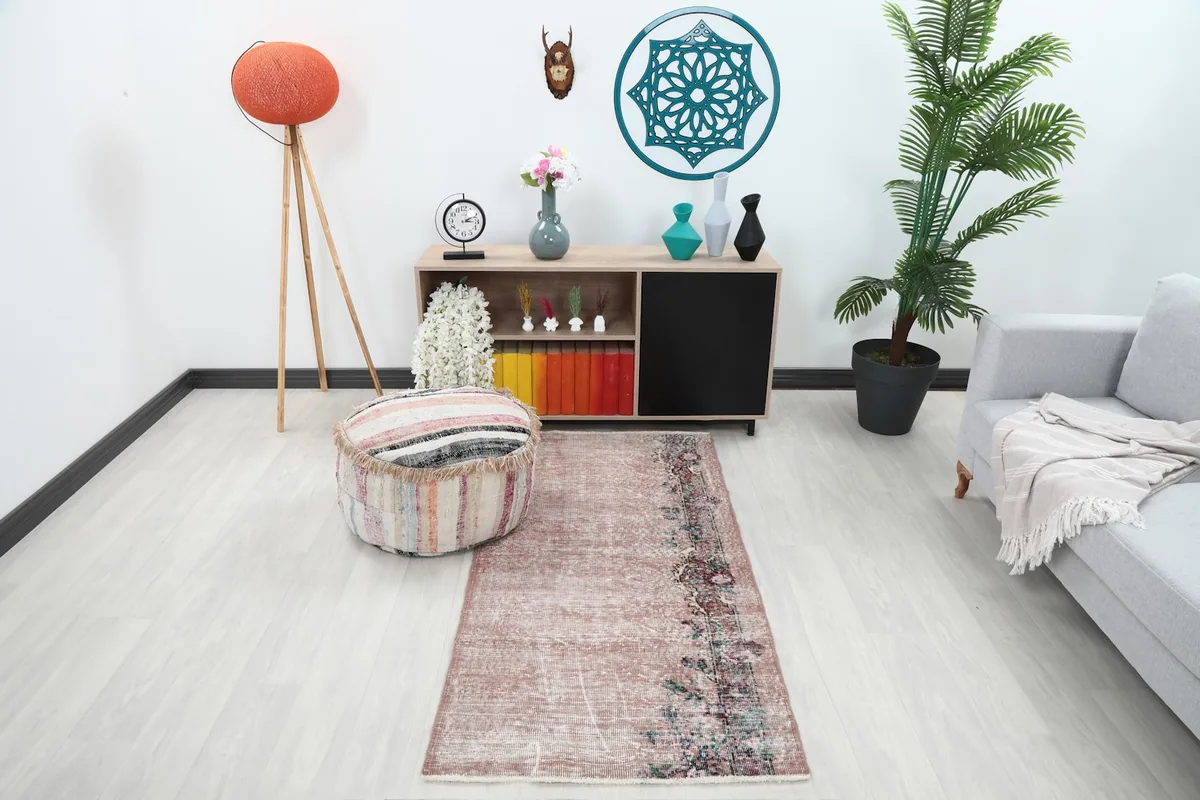 Anatolian rose rug in a modern living room setting with a light gray couch and wooden furniture
