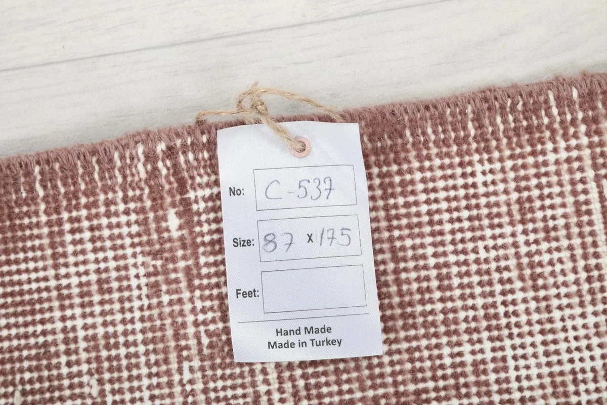 Tag showing the rug's dimensions in centimeters and confirming it is hand-made in Turkey