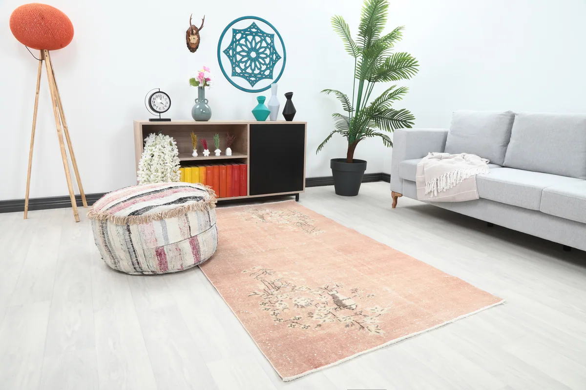 Faded Rose Floral Anatolian Rug from an angle in a room, highlighting its soft rose tones and vintage character.