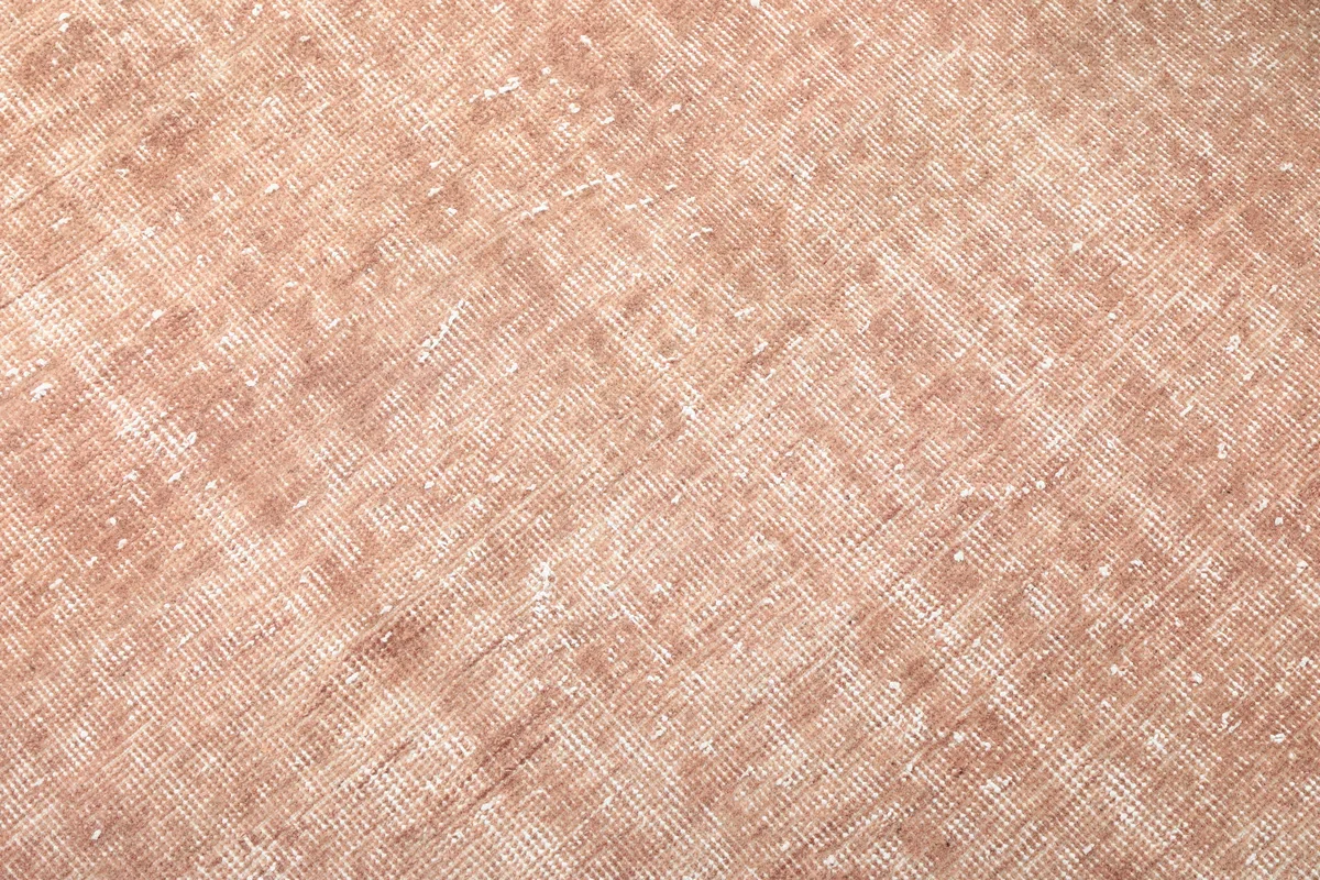 Texture shot of the Faded Rose Floral Anatolian Rug's low wool pile, showing its vintage wear and weave.