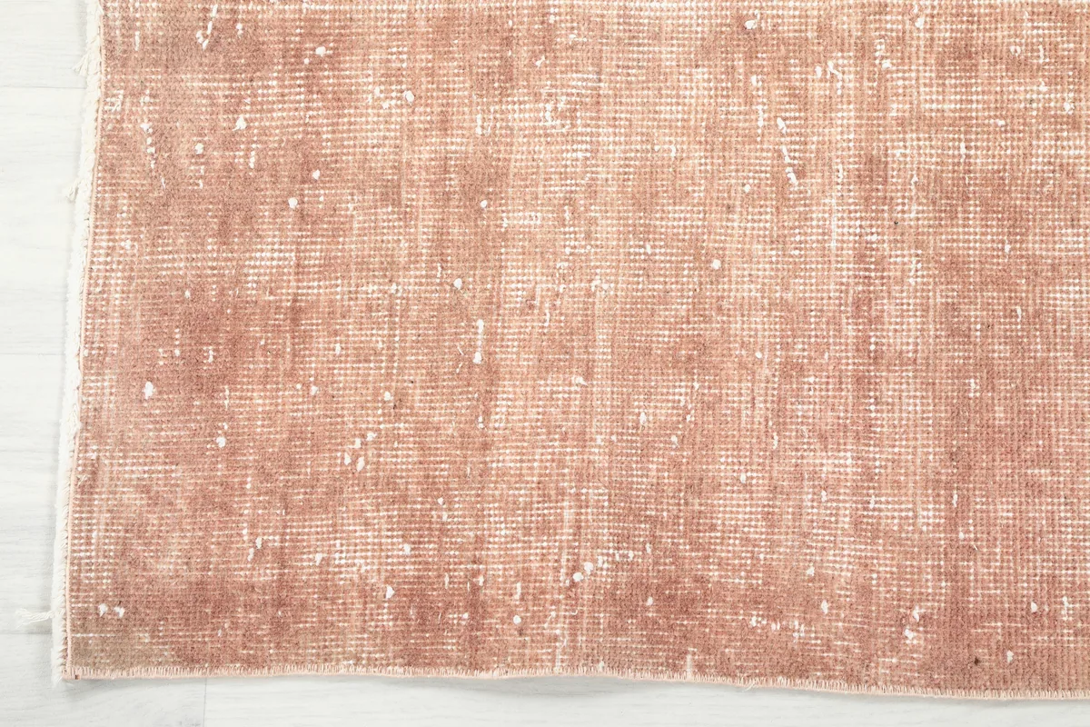 Edge detail of the Faded Rose Floral Anatolian Rug, highlighting the subtle border and faded field.