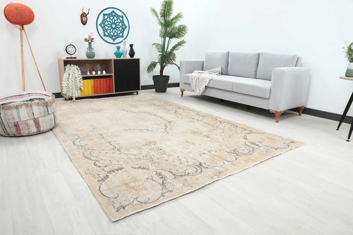 Angled view of the beige and cream vintage rug showing its placement in a spacious living room