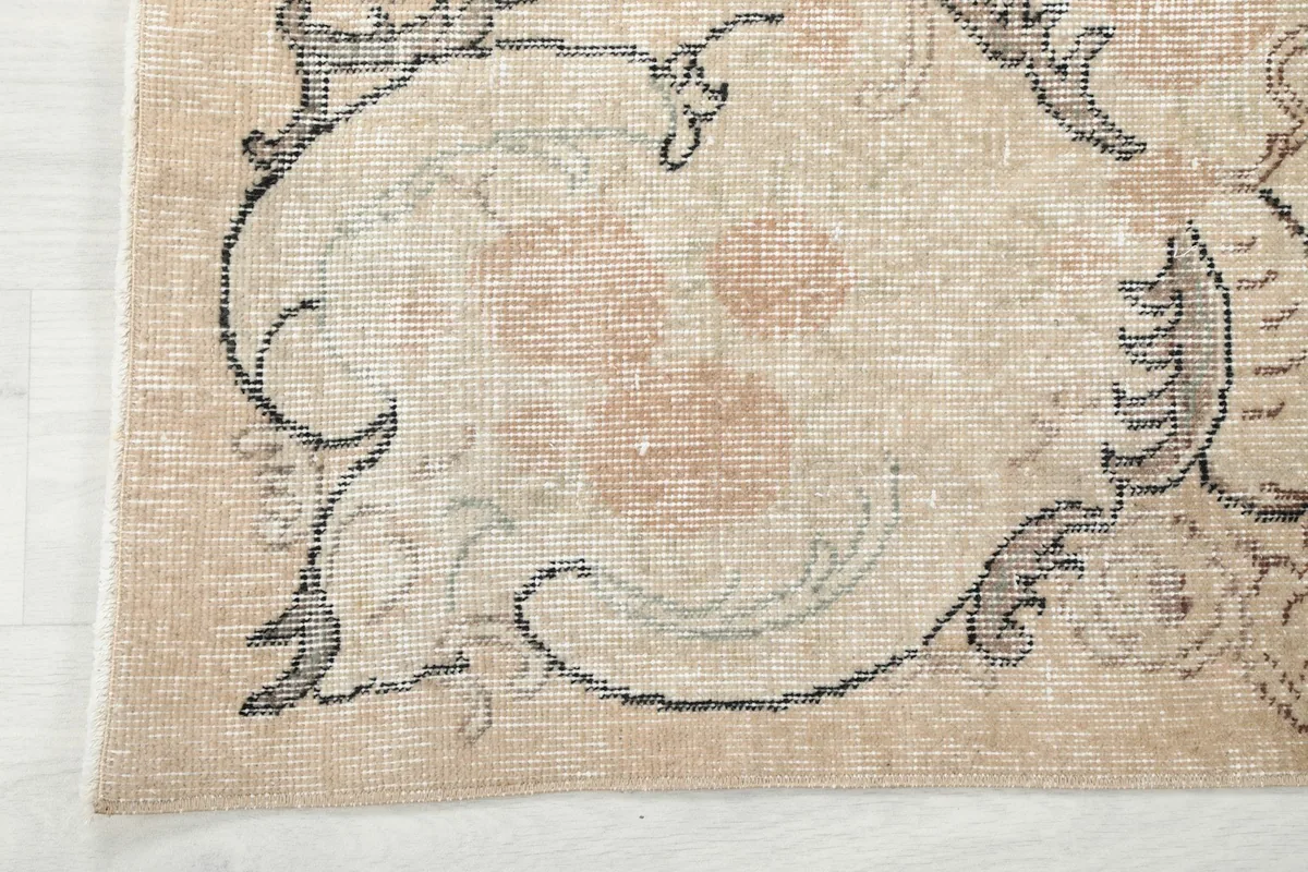 Corner detail of the rug, illustrating the border design and soft color transitions