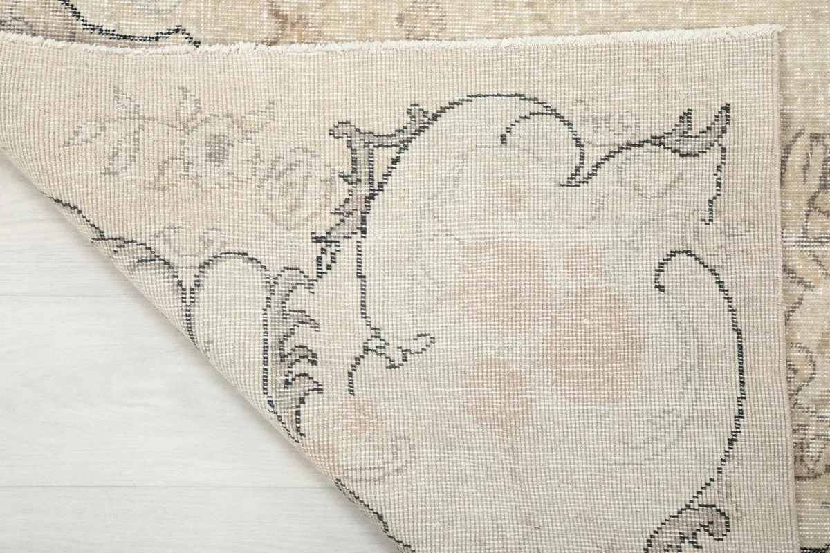 Close-up of the rug's reverse side and hand-knotted construction, with a folded corner