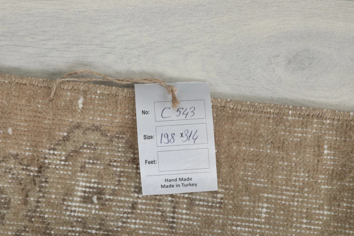 Tag showing the rug's item number and dimensions in centimeters, confirming hand-made origin