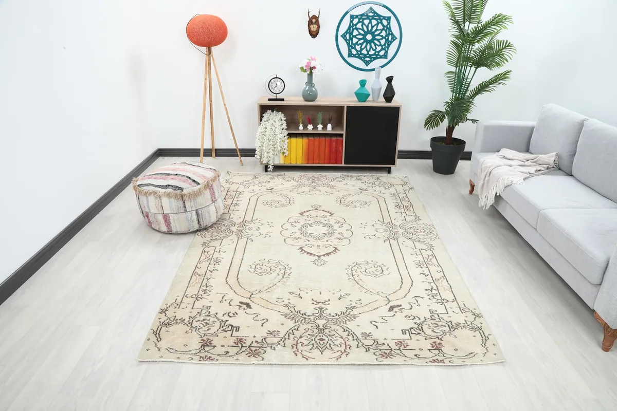 Vintage ivory rug displayed in a modern living room setting with a light gray sofa