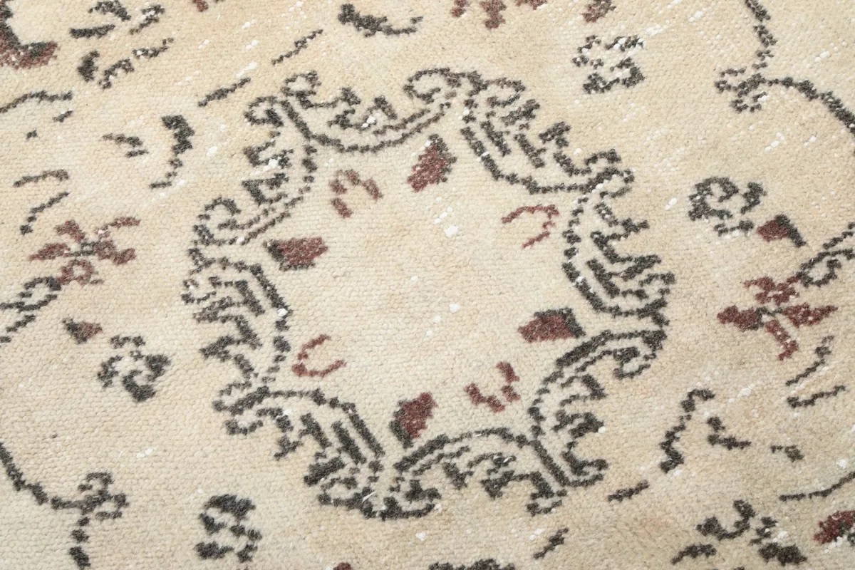 Detailed view of the intricate floral and geometric patterns within the rug's field