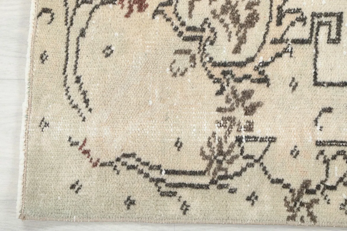 Edge of the rug showing the subtle border design and a hint of the low pile